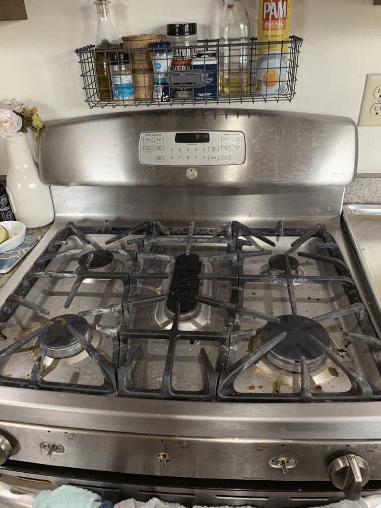 Dirty stainless steel gas range before cleaning