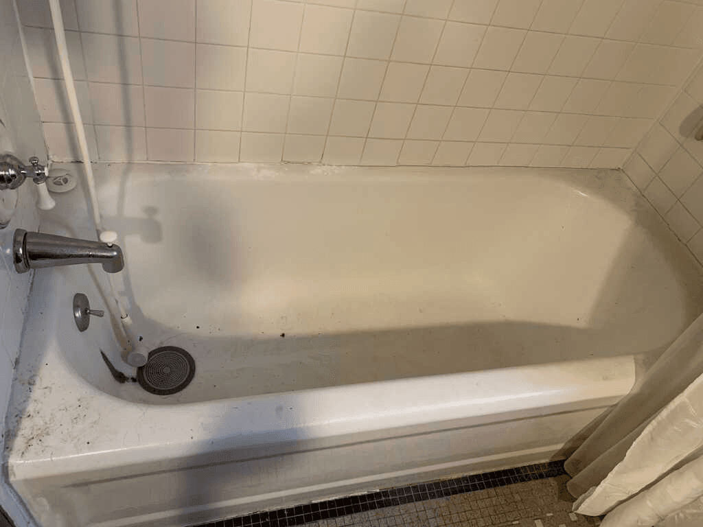 Grimy bathtub before residential cleaning